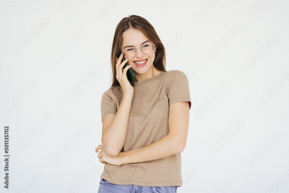 Portrait of a smiling young woman talking on mobile phone isolated over white background Portrait of a smiling young woman talking on mobile phone isolated over white background