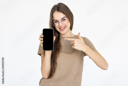 Portrait of a joyful businesswoman showing blank screen mobile phone isolated over white background