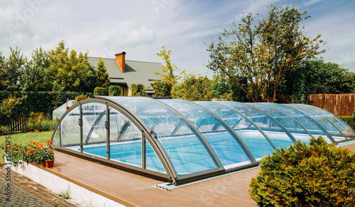Polycarbonate Cover. Outdoor swimming pool with automatic pool cover in the garden.