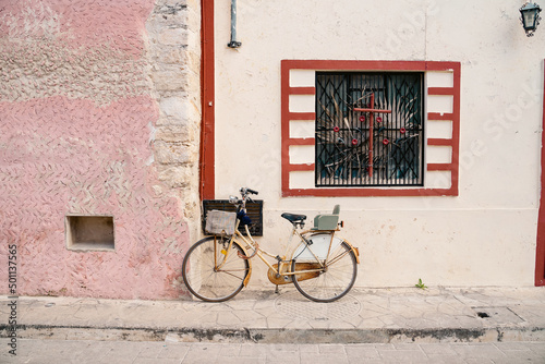bicycle leaning against a pale pink beautiful wall with window atmospheric shabby house in mexican vibe atmosphere of freedom and poverty. Mexica composition