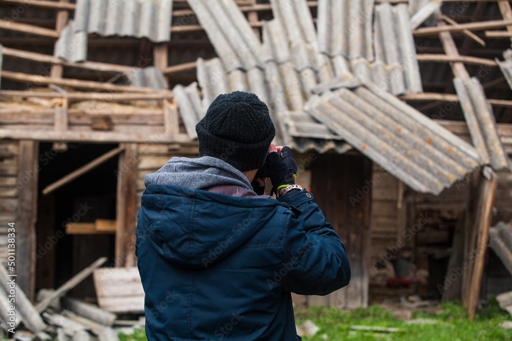 photographer photographing a destroyed house photographer photographing a destroyed house