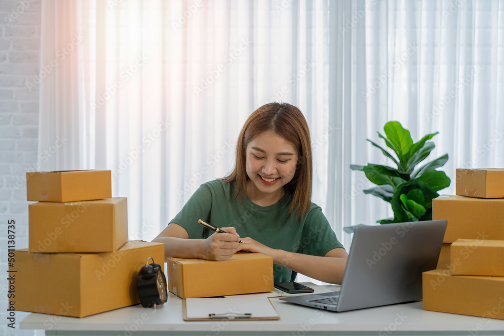 Portrait of Asian young woman SME working with a box at home the workplace.start-up small business owner, small business entrepreneur SME or freelance business online and delivery concept. Portrait of Asian young woman SME working with a box at home the workplace.start-up small business owner, small business entrepreneur SME or freelance business online and delivery concept.