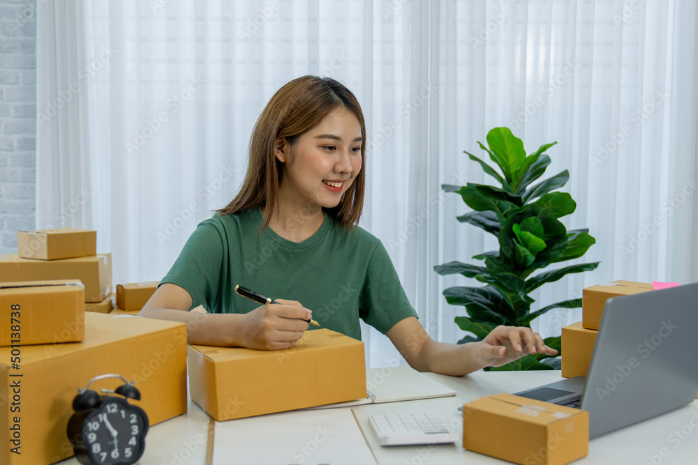 Starting Small business entrepreneur freelance,Portrait young woman working at home office, BOX,smartphone,laptop, online, marketing, packaging, delivery, SME, e-commerce concept Starting Small business entrepreneur freelance,Portrait young woman working at home office, BOX,smartphone,laptop, online, marketing, packaging, delivery, SME, e-commerce concept