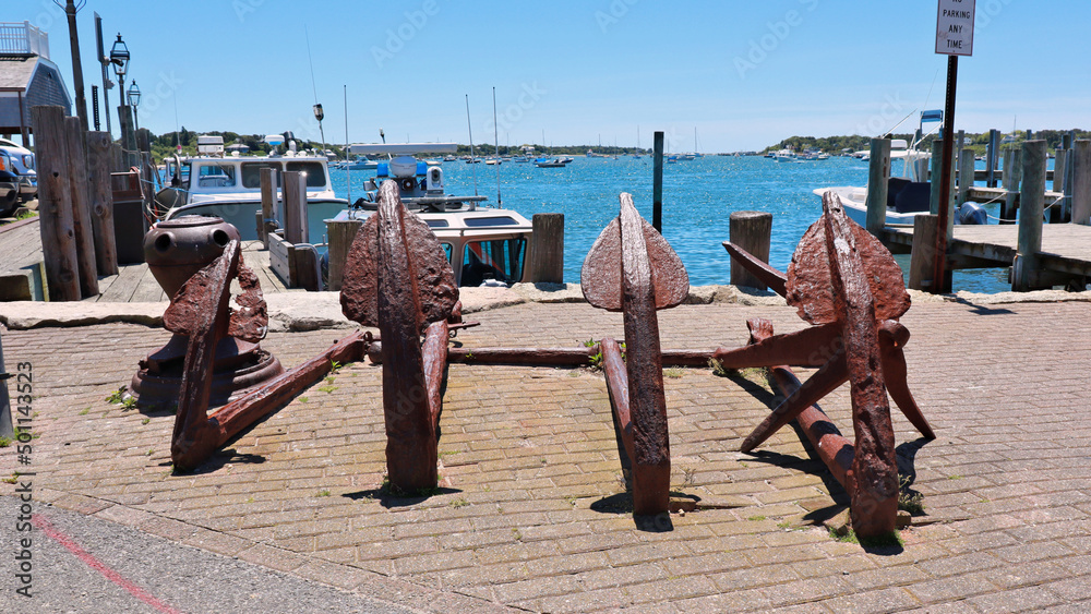 Four old rusted anchors in display on a pier of Edagartown, Martha's Vineyard, MA