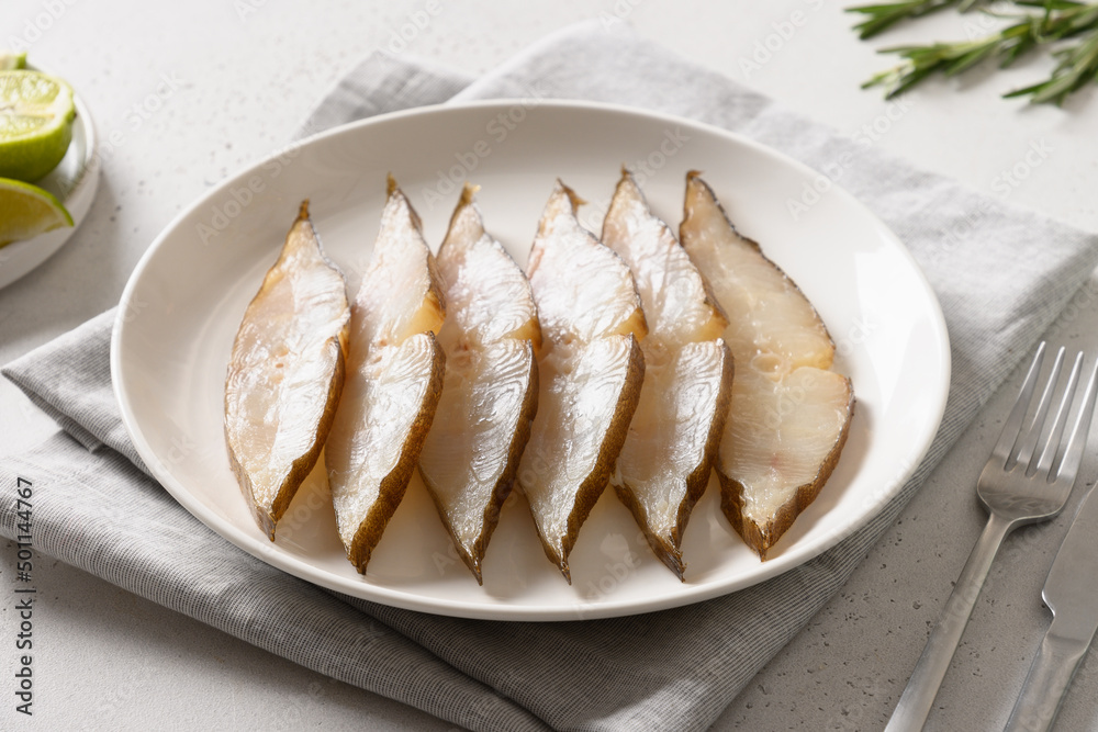 Cold appetizer smoked halibut for festive party on white background. Close up. Cold appetizer smoked halibut for festive party on white background. Close up.