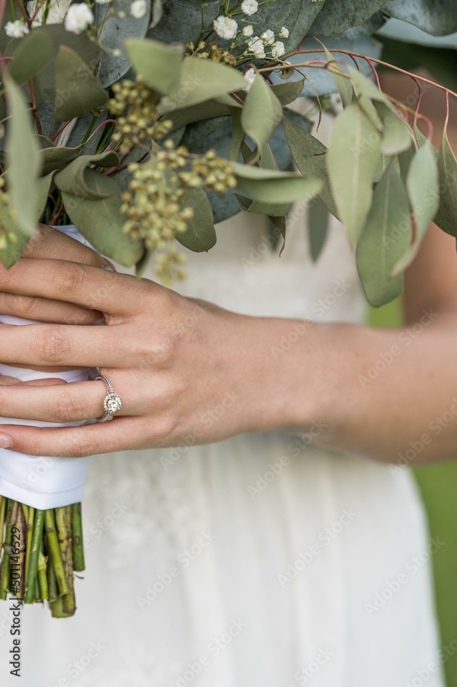 Bride holding wedding bouquet showing off engagement ring