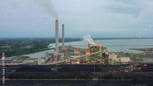 Fly around coalfield and industrial ultra-supercritical coal-fired power plant with smokes raising from chimney located at lekir bulk terminal jalan, teluk rubiah, manjung, malaysia. photo