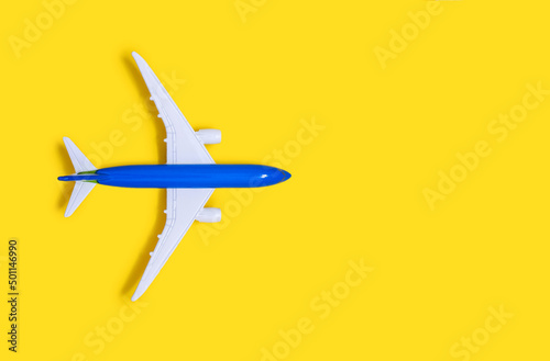 Airplane model on a yellow background with free space for text or advertising. Tourism or freight transport concept. Toy airplane on a red background with a top view