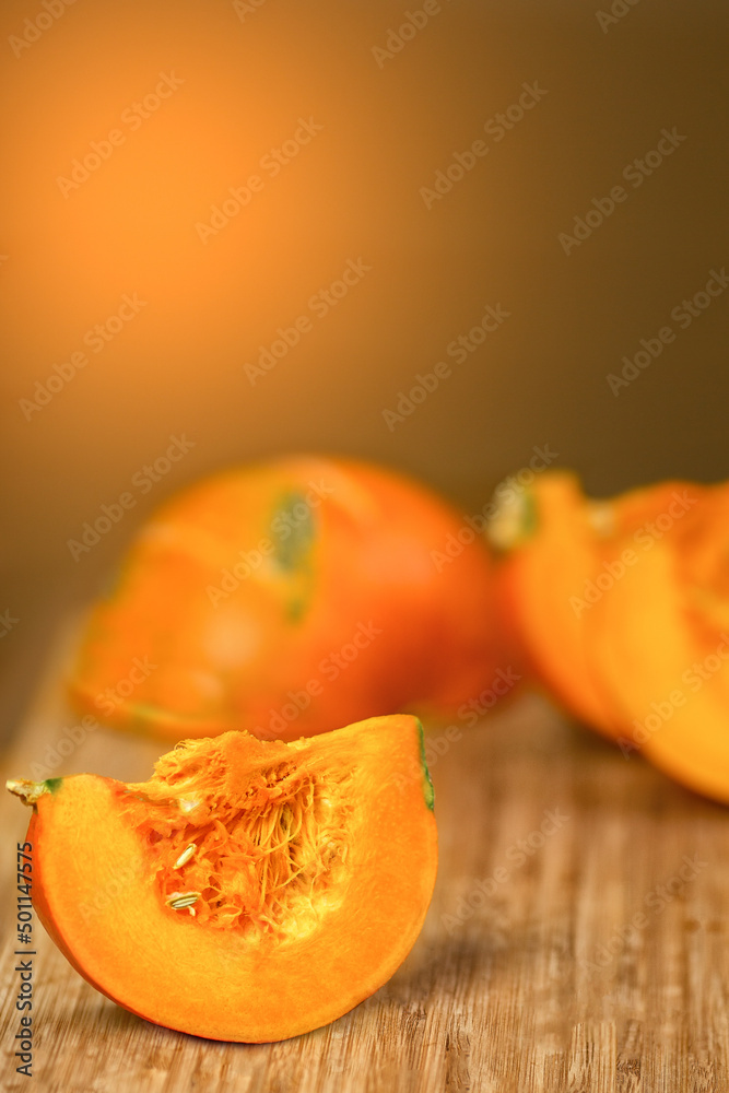 Pumpkin slices on an orange wooden background Pumpkin slices on an orange wooden background