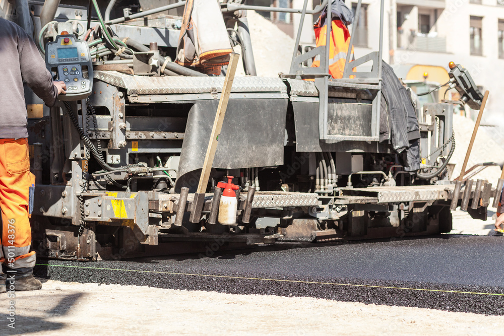 Asphalt laying. Road repair, compactor lays asphalt. Heavy special machines. Construction Asphalt Road. Asphalting concept.