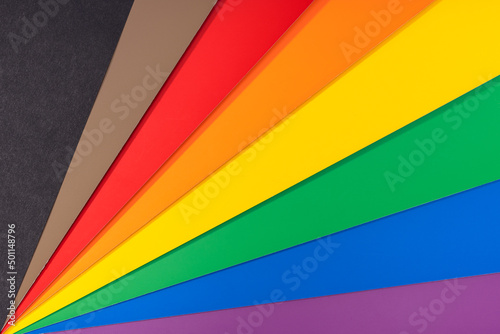 New LGBT Rainbow flag background with black and brown stripes. Group of colored cardboard. Gay pride flag
