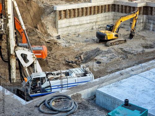 View on the building construction site and working of hevy machines while digging foundation photo