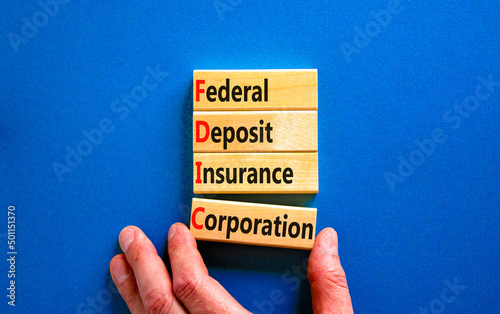 FDIC federal deposit insurance corporation symbol. Concept words FDIC federal deposit insurance corporation on blocks on blue background. Business FDIC federal deposit insurance corporation concept. photo