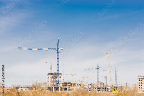 Construction of multi-storey buildings. Tower cranes build high-rise buildings in the steppe