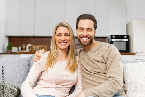 Close-up portrait of happy caucasian couple in love hugging and looking at the camera with cheerful smiles. Relationships concept. Stock photo