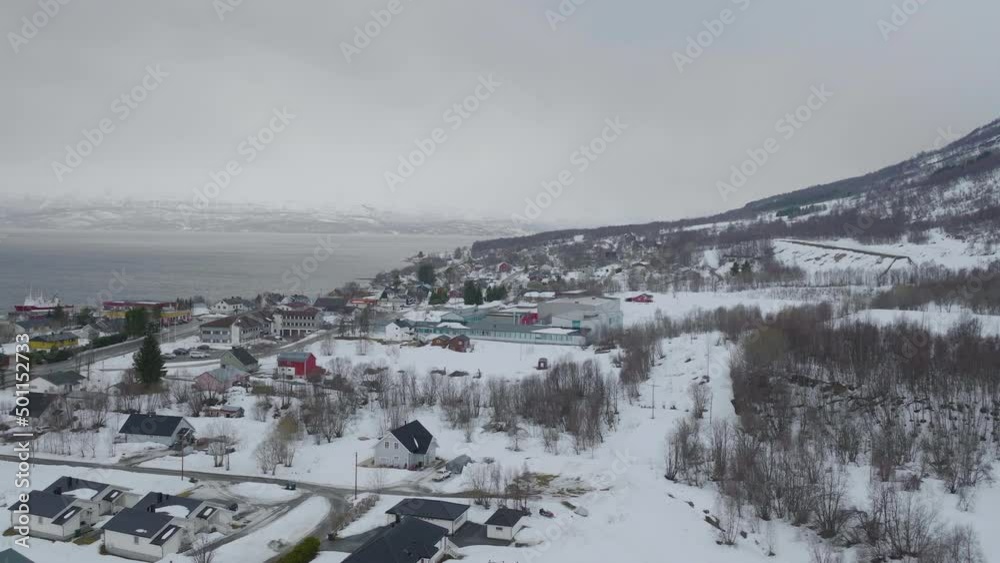 Aerial view of a snow covered town in Norway with mountains and fjord