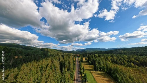 Top aerial view of green forest and road with car in mountains. Beautiful landscape cloud sky photo