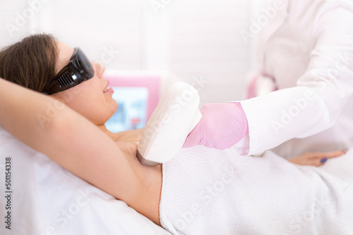 Diode laser hair removal, Beautician removes hair on beautiful female armpits, Hair removal for smooth skin, laser procedure at beauty studio or clinic, Body care epilation treatment.