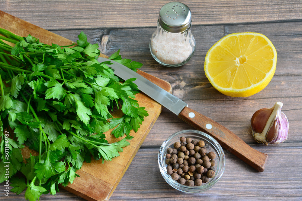 green fresh bunch of parsley on cutting board with kitchen knife