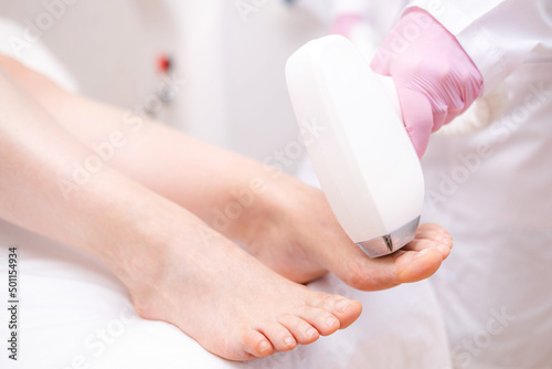Diode laser hair removal, Beautician removes hair on beautiful female legs, Hair removal for smooth skin, laser procedure at beauty studio or clinic, Body care epilation treatment.