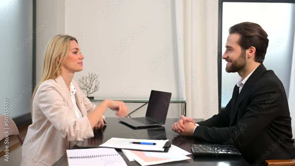 Make deal. Side view profile of cheerful young successful business partners wearing official clothes are sitting opposite and shaking hands with smile Make deal. Side view profile of cheerful young successful business partners wearing official clothes are sitting opposite and shaking hands with smile