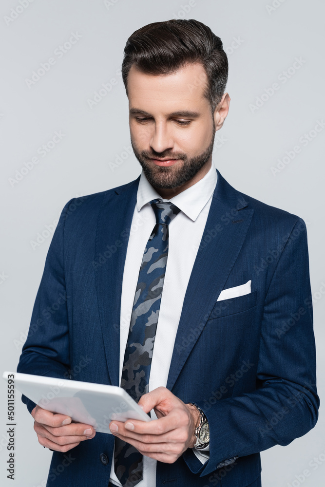 brunette economist in blue blazer using digital tablet isolated on grey. brunette economist in blue blazer using digital tablet isolated on grey.