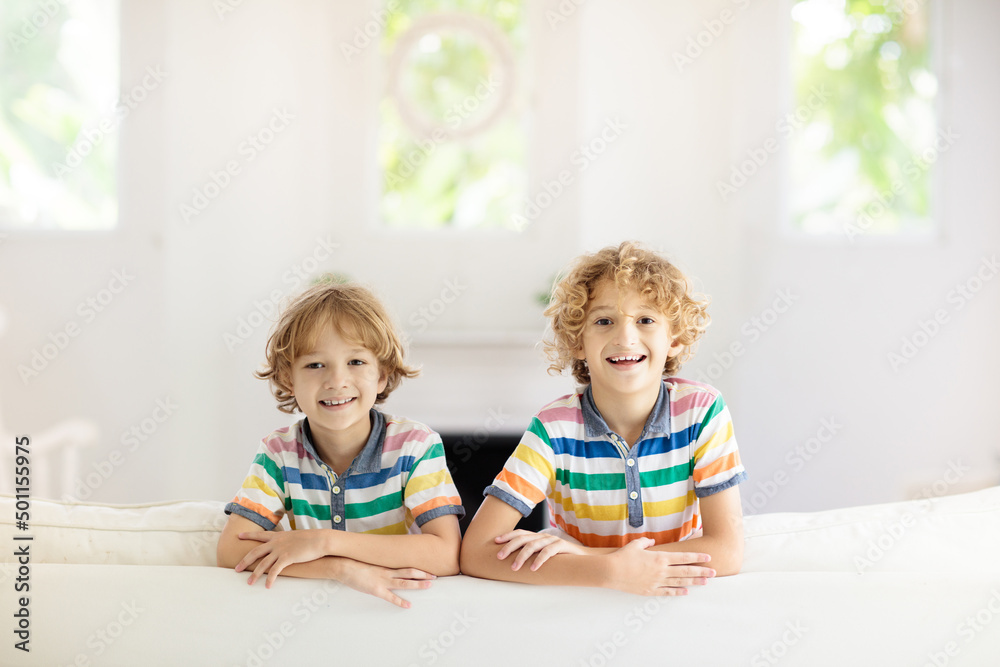 Kids play and watch tv on couch. Child at home. Kids play and watch tv on couch. Child at home.