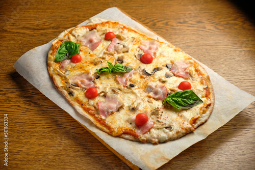 Pizza with bacon and ham and tomatoes