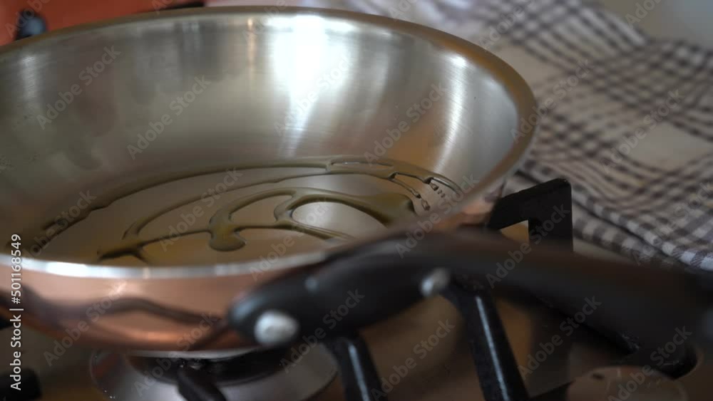 Woman puts the frying pan on with oil for cooking Woman puts the frying pan on with oil for cooking