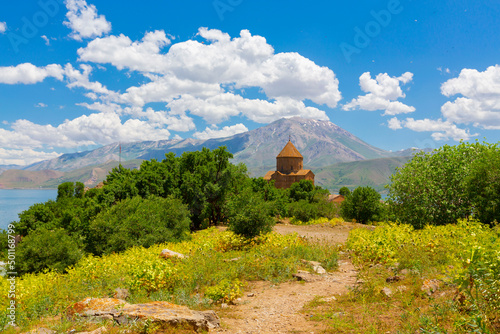 Amazing spring view of Armenian Church of the Holy Cross on Akdamar Island (Akdamar Adasi), Lake Van/Turkey. Surrounded by tree in blossom, in a middle of Akdamar Island. photo