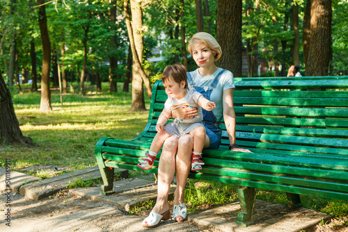 beautiful girl with children sits on a bench in the park © Minakryn Ruslan 