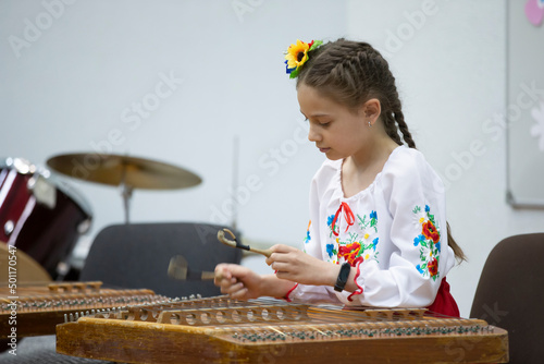 The girl plays the ethnic instrument dulcimer photo