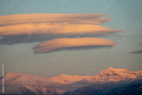 Lenticular clouds over snowy mountains at sunset © Miguel Ángel RM