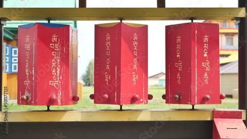 Rotation of the red prayer drums outside the Buddhist temple. photo