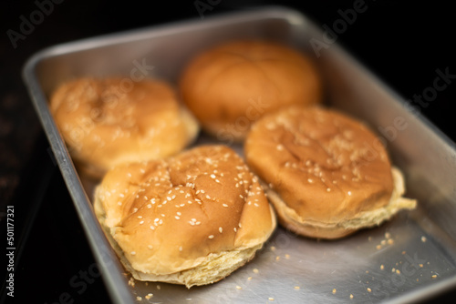 Four Hamburger Buns in a tin tray