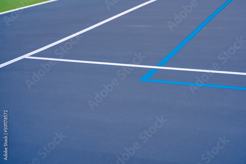 Blue tennis court with white lines and light blue pickleball lines. 
