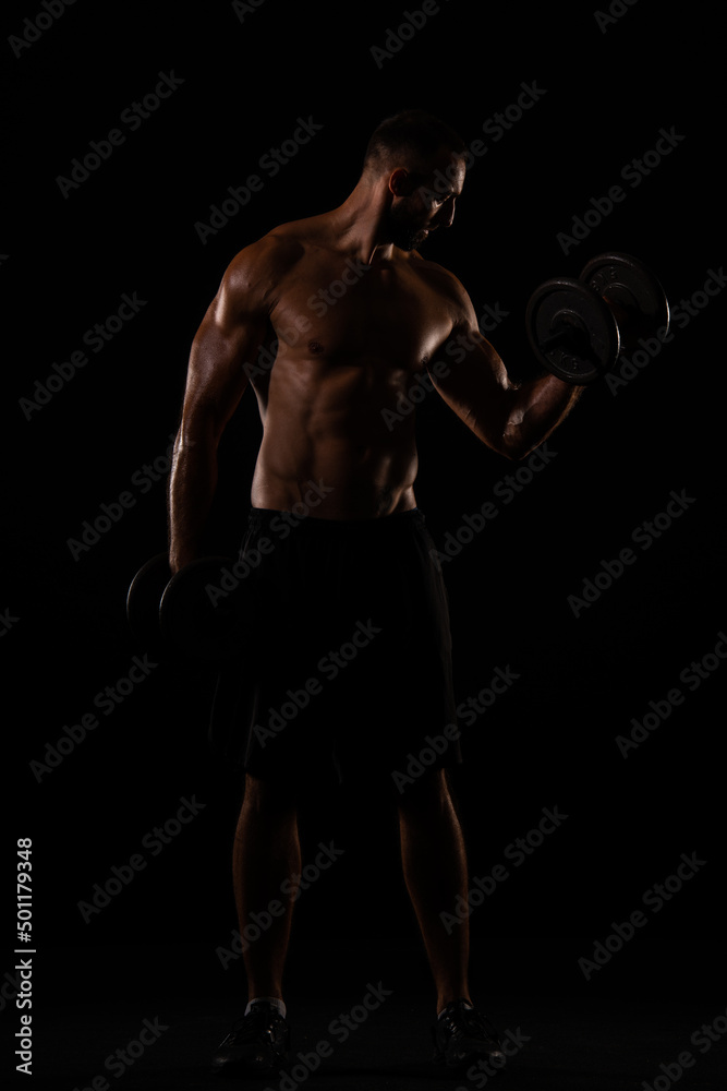 Fototapeta premium Topless guy lifting weights in the gym