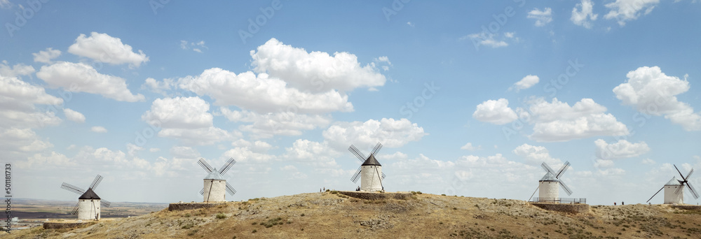 Consuegra town with windmills located on hill against cloudy sky Consuegra town with windmills located on hill against cloudy sky