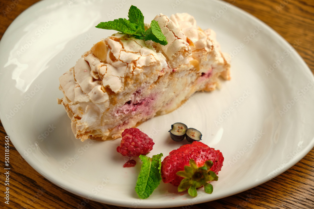 Cake with meringue roll with cream and raspberries