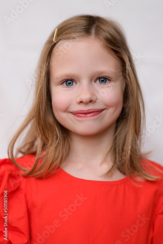 Portrait of beautiful smiling little girl in red dress
