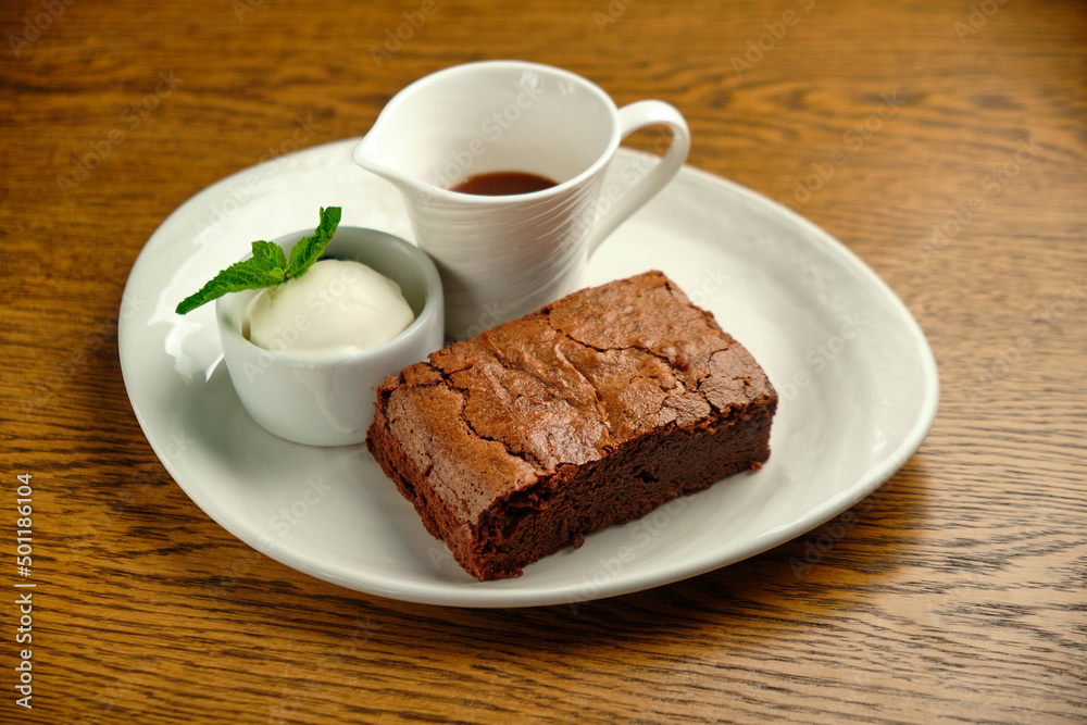 Chocolate cakes on a wooden table with ice cream and mint leaf on top Chocolate cakes on a wooden table with ice cream and mint leaf on top