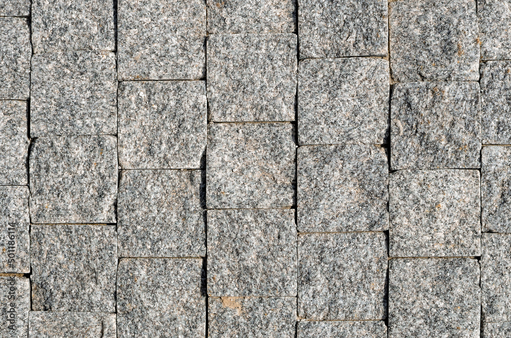 Obraz premium Street paved with cobblestone. paving stones, close-up.