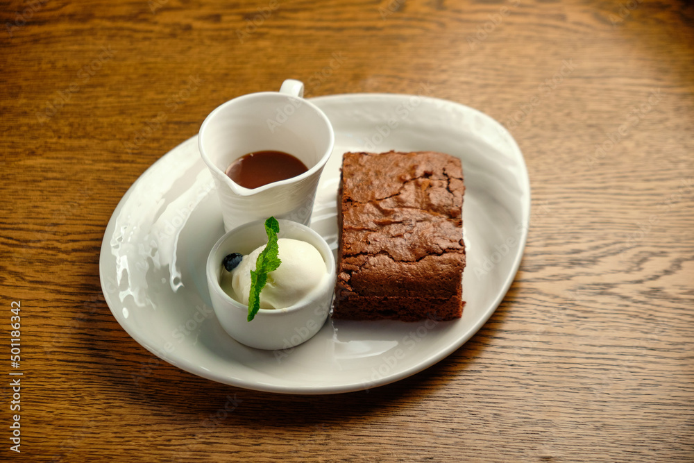 Chocolate cakes on a wooden table with ice cream and mint leaf on top Chocolate cakes on a wooden table with ice cream and mint leaf on top