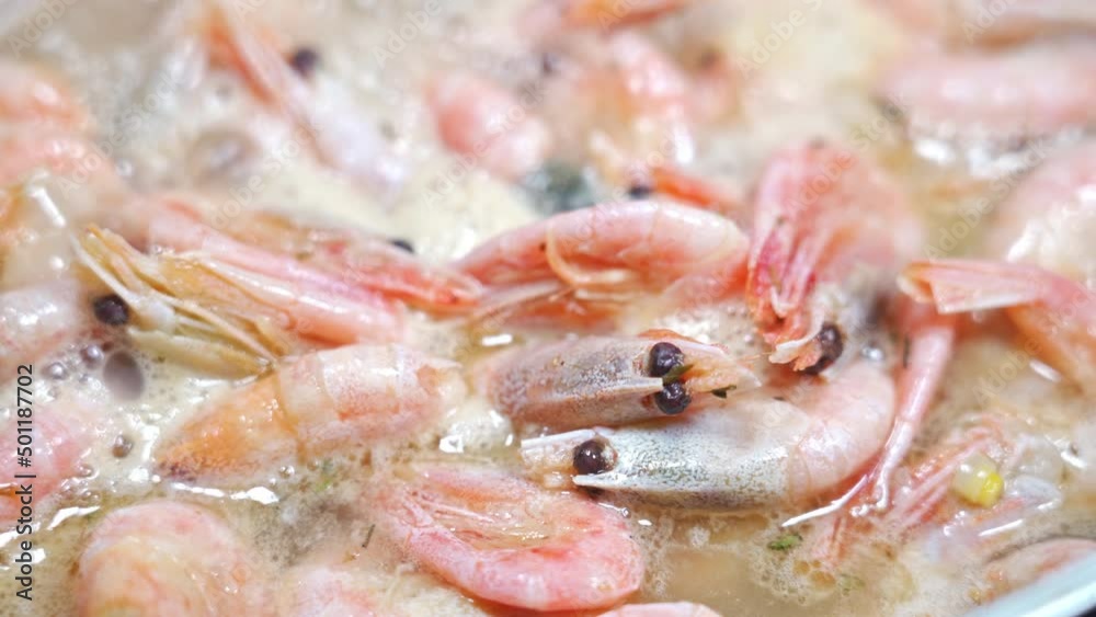 Close-up of shrimp frying in a frying pan, shrimp in butter with garlic.