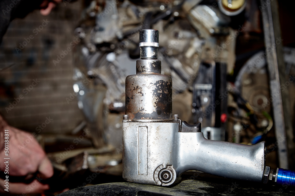 A professional mechanic works on a car engine in a garage. Car service. A professional mechanic works on a car engine in a garage. Car service.