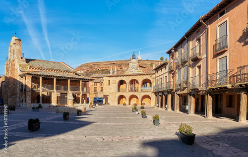 Plaza mayor del pueblo medieval de Ayllon,en Segovia, Castilla y Leon,España,observándose el  Ayuntamiento y la Iglesia románica de San Miguel, soportales antiguos y el mirador de la montaña.