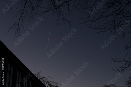Foto A lonely plane streaking across the night sky high above.