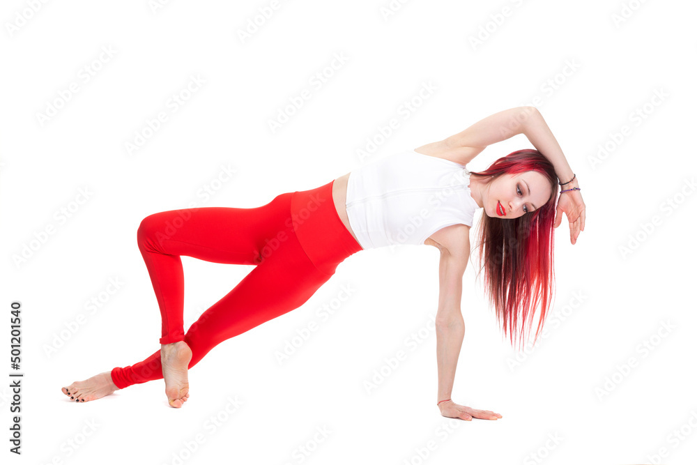 A beautiful, athletic, slim, smiling and cheerful woman in a white top and red sweatpants performs stretching and Pilates elements. Lifestyle concept with sports and gym, healthy lifestyle. Isolated A beautiful, athletic, slim, smiling and cheerful woman in a white top and red sweatpants performs stretching and Pilates elements. Lifestyle concept with sports and gym, healthy lifestyle. Isolated