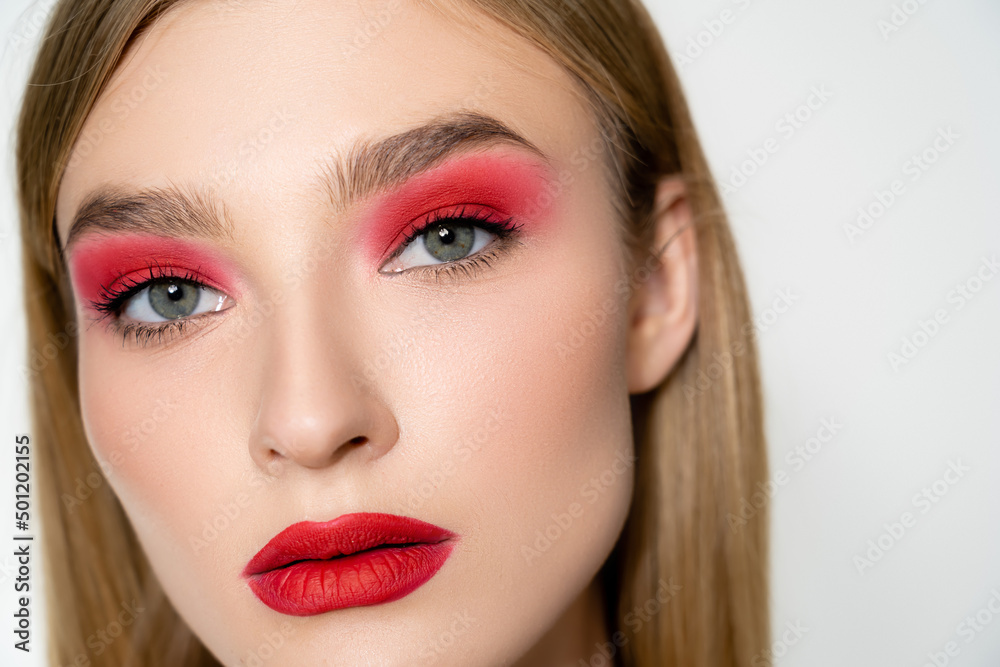 Portrait of young model with red visage looking at camera isolated on grey. Portrait of young model with red visage looking at camera isolated on grey.
