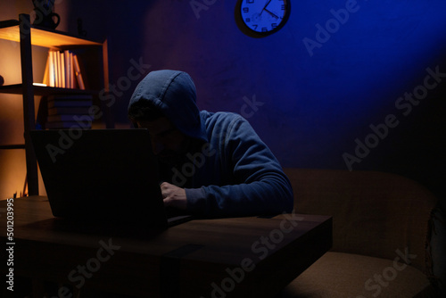 Hacker man working laptop computer. Hacker attack in dark room